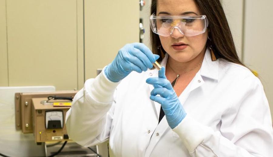 Researcher Tyler Spano examines a sample of uranyl nitrate solution