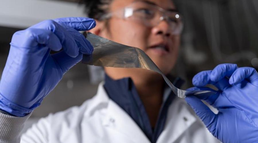 Researcher Yuhgene Liu holds an aluminum material for solid-state batteries.