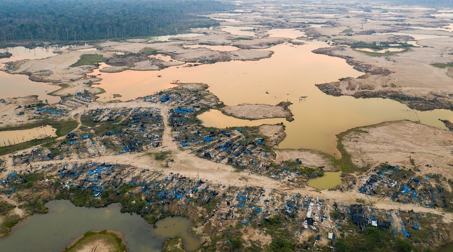 A former mining camp shows where shallow mining ponds have overwhelmed a former river system in the La Pampa region of Madre de Dios, Peru